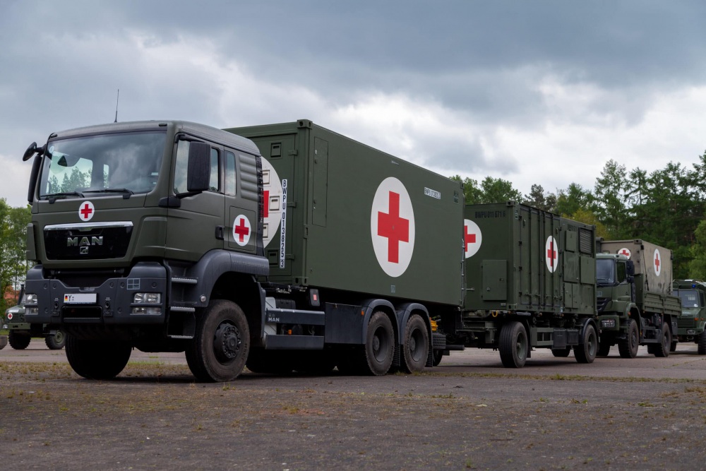 Army vehicles in a line delivering aid